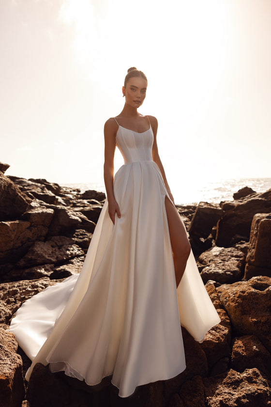 Robe de mariée Alya en satin mat, avec haut corseté et fines bretelles — vue de face, allure minimaliste.