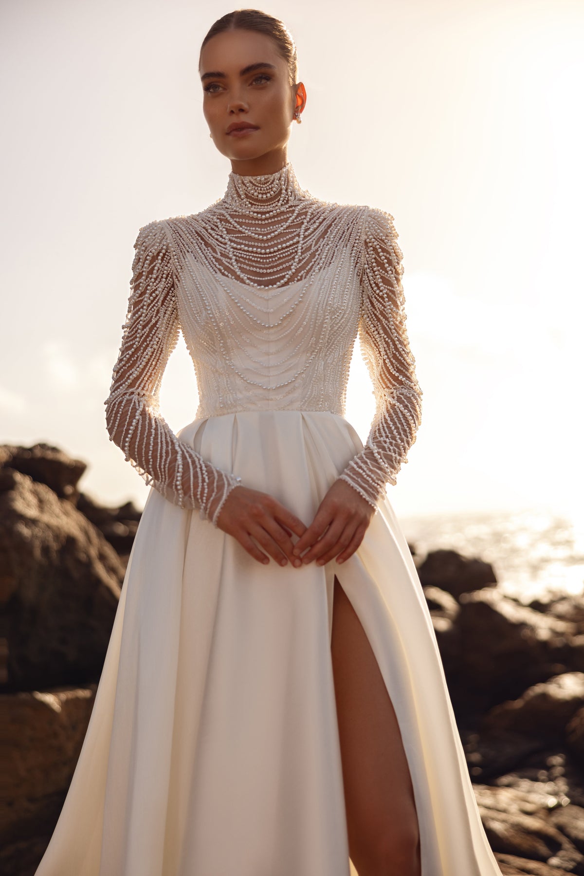 Blouse de mariée Alya à longues manches ornées de perles, portée avec une jupe à fente haute.