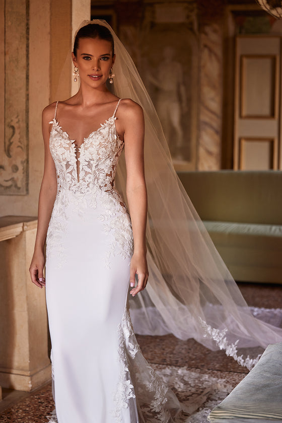 Voile de mariée long et classique Apolonia, bordé de dentelle florale et fixé par un peigne, de l’atelier DAMA Couture — vue de face.