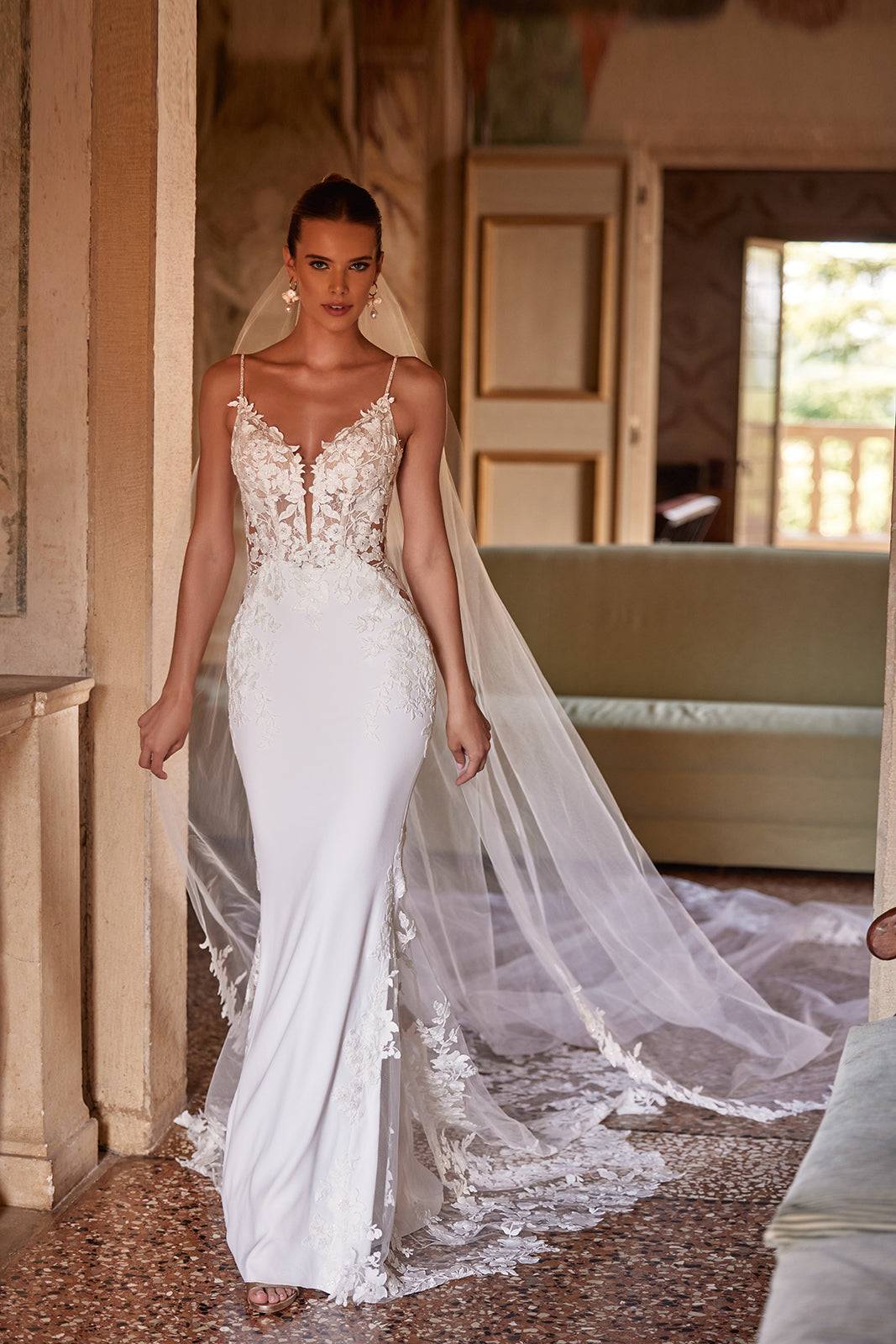 Voile de mariée long et classique Apolonia, bordé de dentelle florale et fixé par un peigne, de l’atelier DAMA Couture — vue de face.