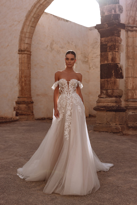 Robe de mariée Ariella, avec un corset à baleines apparentes et des appliqués de dentelle florale.