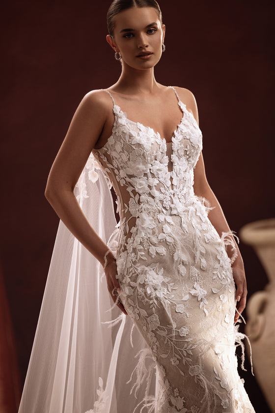 Longue cape de mariée Aspasia, avec des broderies de dentelle sur la traîne.