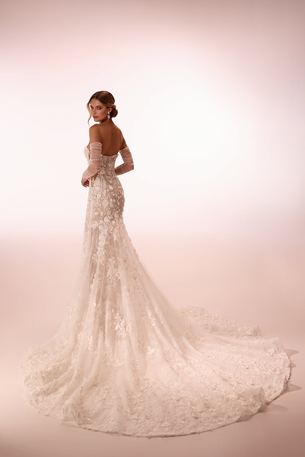 Robe de mariée sirène Ellyse en dentelle à manches longues, allure glamour, DAMA Couture — vue de dos en studio.