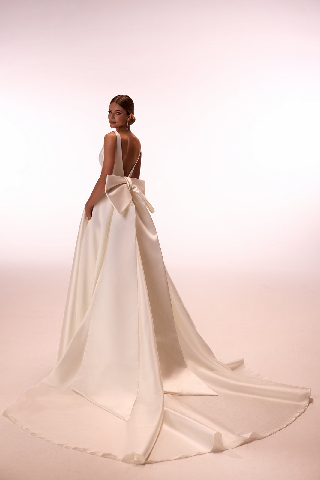 Robe de mariée classique Margo avec traîne à nœud, DAMA Couture — vue de dos en studio.