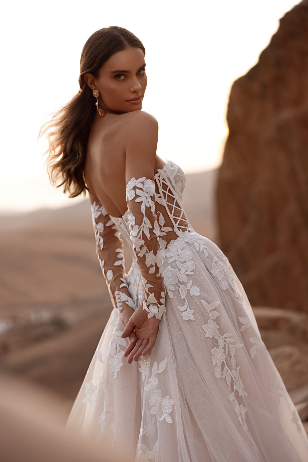 Robe de mariée princesse Nabila, avec un décolleté aux épaules dénudées et une traîne fluide en tulle.