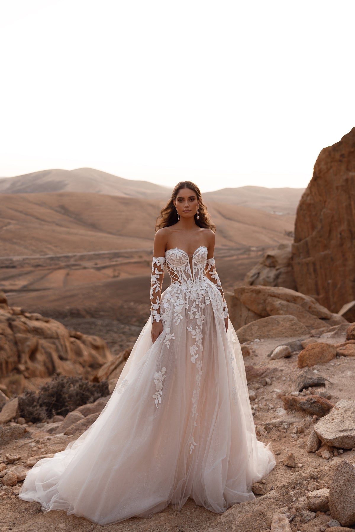 Robe de mariée Nabila, avec un long voile cathédrale et des manches en dentelle.