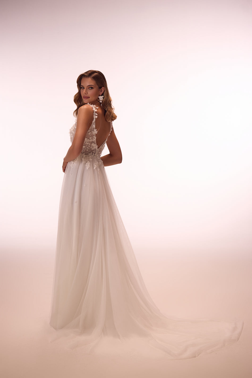Robe de mariée trapèze romantique en dentelle à manches amovibles, DAMA Couture — vue de dos en studio.