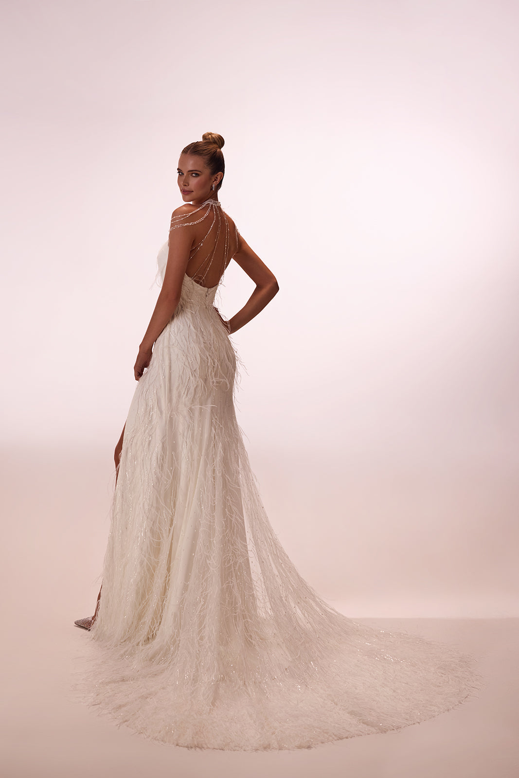 Robe de mariée ornée de plumes, allure glamour, DAMA Couture — photo en studio.