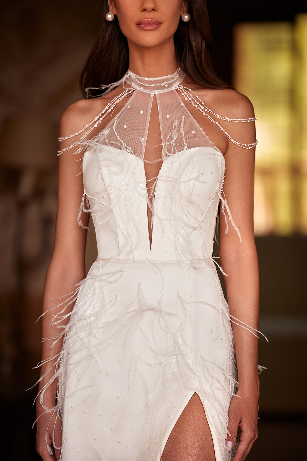 Robe de mariée ornée de plumes, allure glamour, DAMA Couture — gros plan.