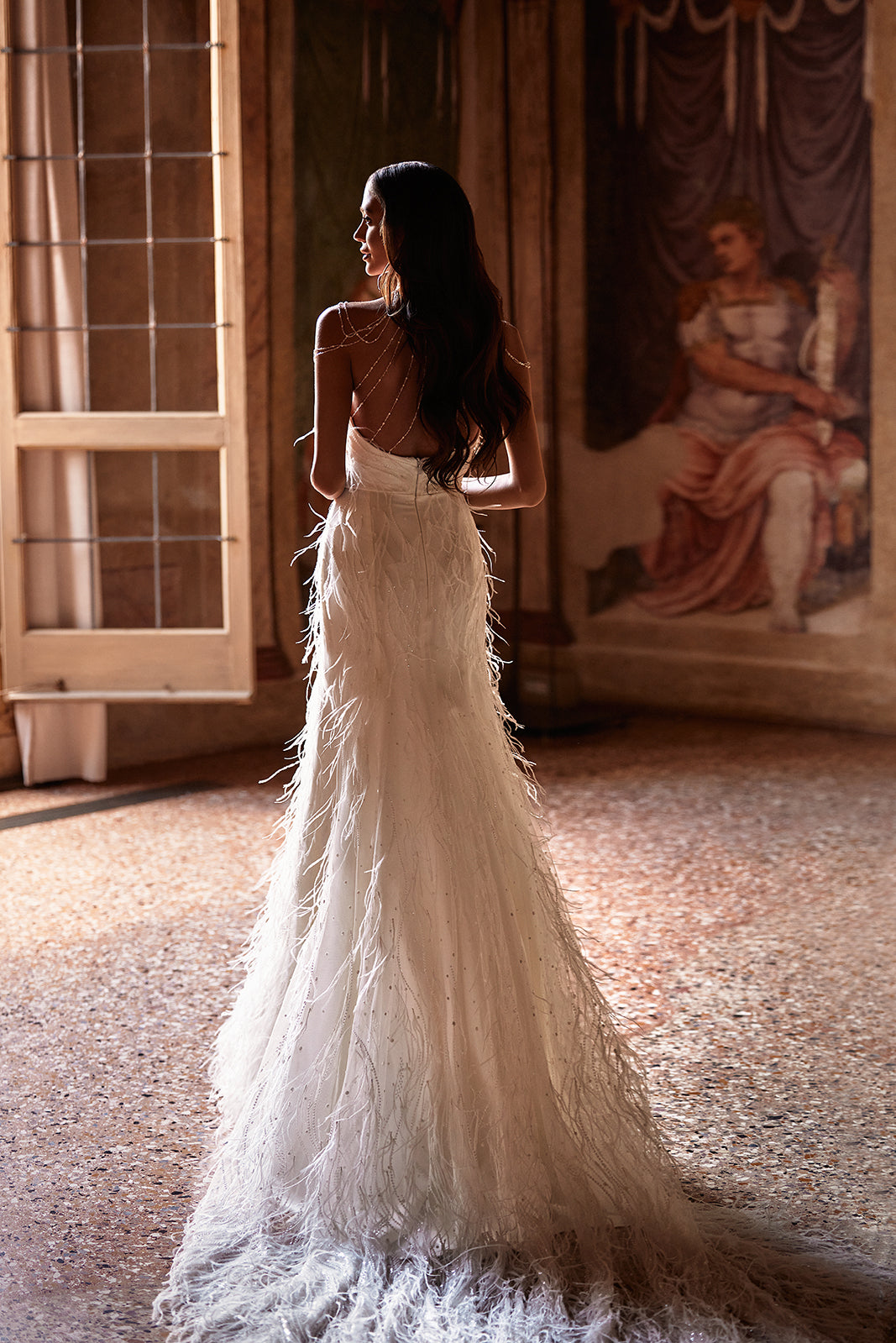 Robe de mariée ornée de plumes, allure glamour, DAMA Couture — vue de dos.