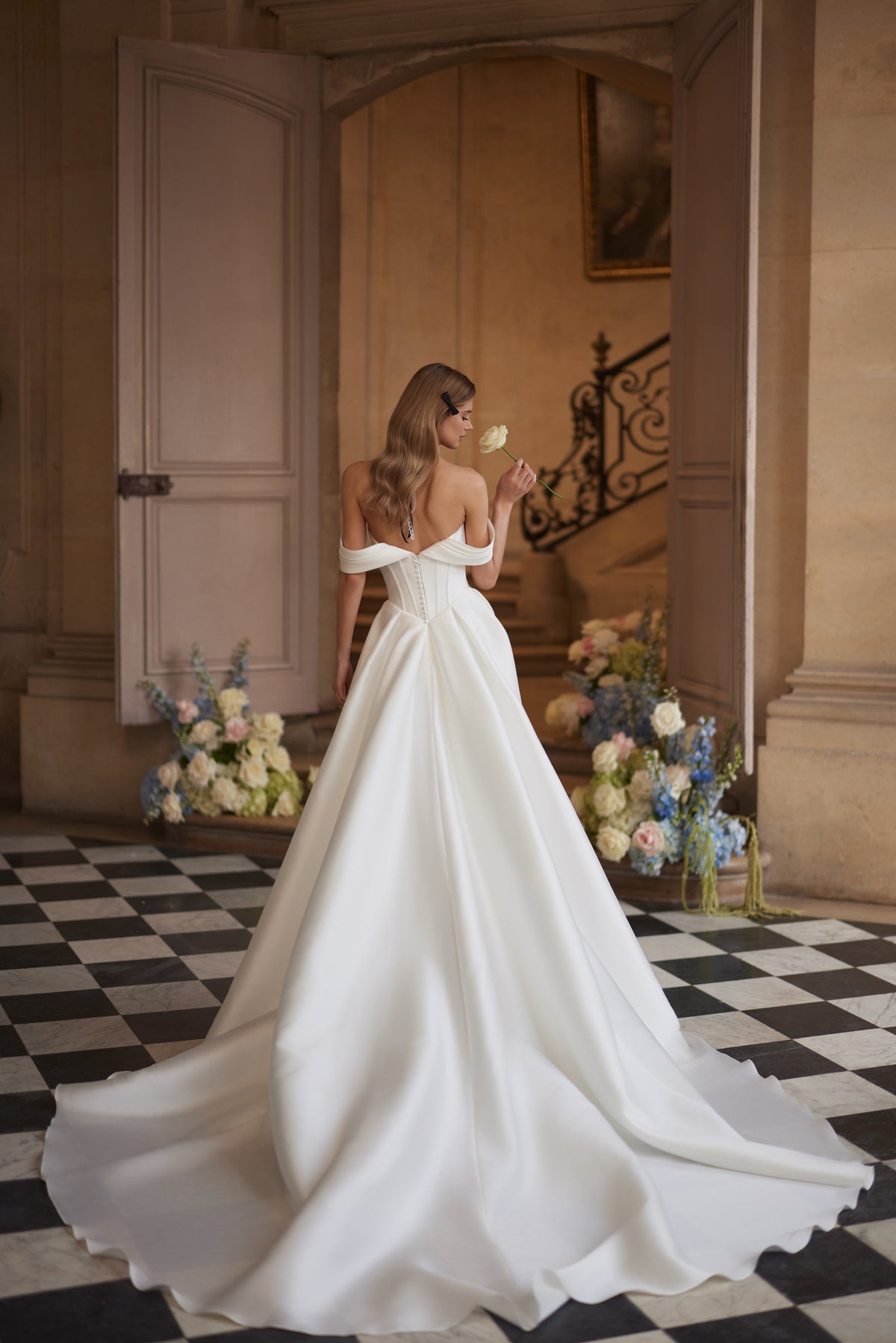 Robe de mariée Alienor, avec des manches drapées laissant les épaules dénudées et une jupe épurée en satin.