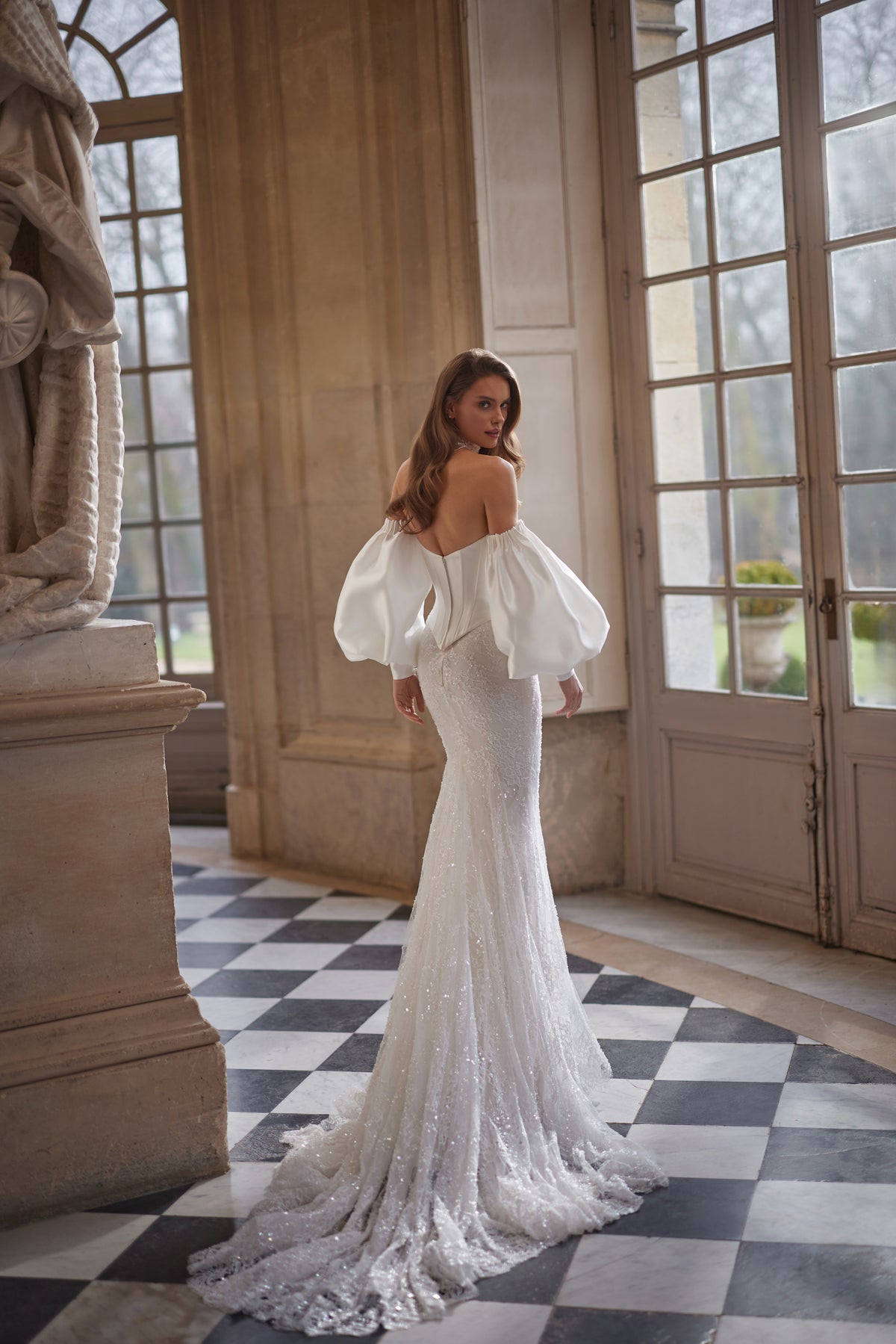 Robe de mariée Anais, avec un corsage sculpté en dentelle et des manches volumineuses laissant les épaules dénudées — collection Something Blue 2027, DAMA Couture.