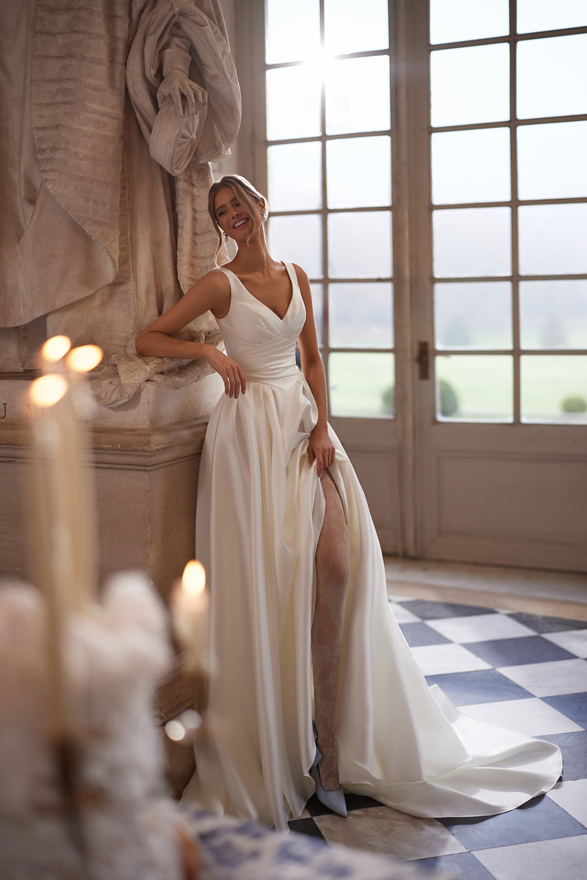 Robe de mariée trapèze Elvira, avec un décolleté en V ouvert et une jupe drapée épurée avec une fente haute.