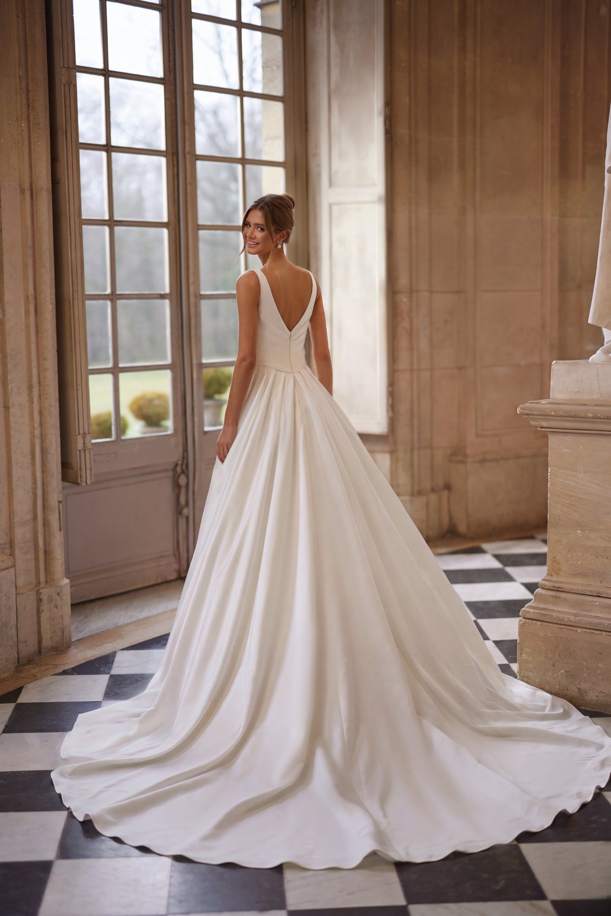 Robe de mariée Elvira, avec un décolleté en V ouvert et une jupe drapée épurée avec une fente haute — collection Something Blue 2027.