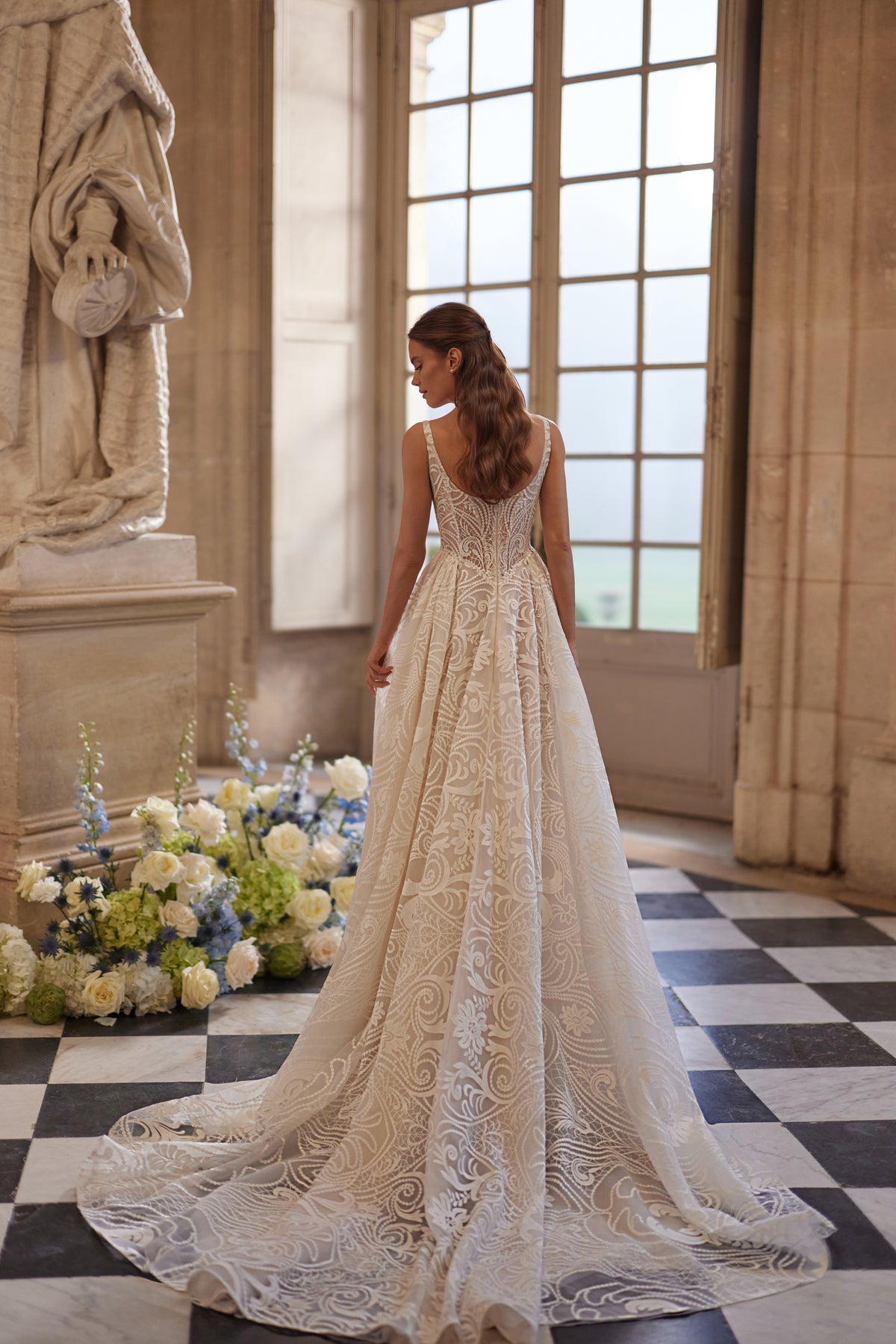 Robe de mariée Frigga, avec de fines bretelles, un décolleté carré et une jupe de bal en dentelle graphique.