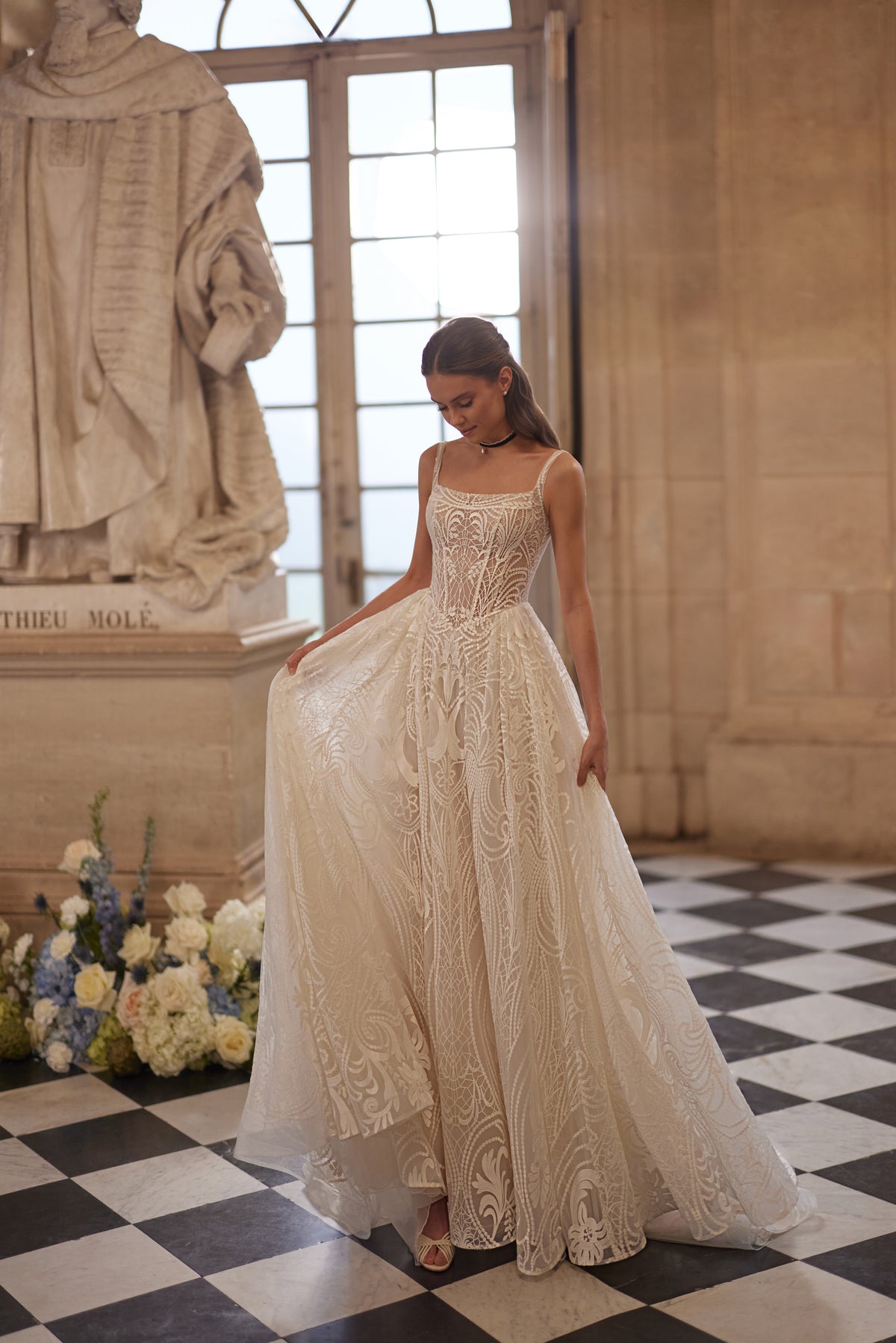 Robe de mariée Frigga, avec de fines bretelles, un décolleté carré et une jupe de bal en dentelle graphique — collection Something Blue 2027, DAMA Couture.