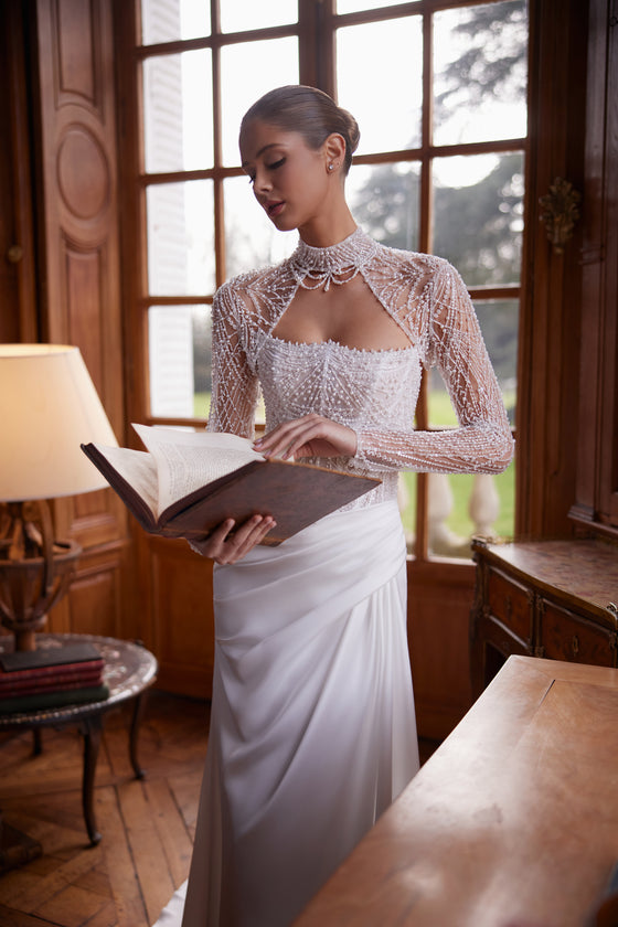 Robe de mariée sirène Greta, avec un corset sans bretelles richement perlé et une jupe drapée en satin.
