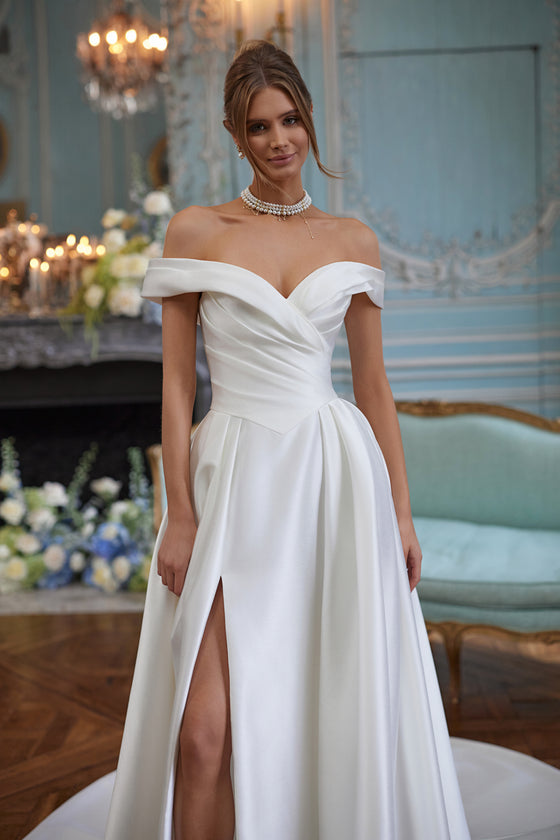 Robe de mariée Heloise, avec un décolleté souplement drapé aux épaules dénudées, en satin épuré — collection Something Blue 2027, DAMA Couture.