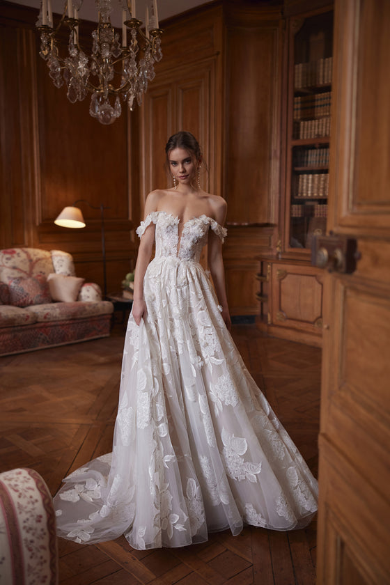 Robe de mariée Hydragenea, avec un décolleté plongeant et des bretelles florales retombant sur les bras.