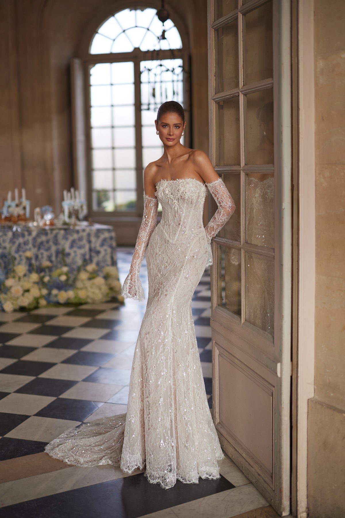 Robe de mariée Irulian, avec un corsage scintillant sans bretelles et une coupe ajustée en dentelle.