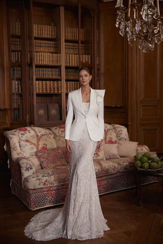 Veste de mariée structurée Irulian à manches longues, portée sur la robe de mariée Irulian.