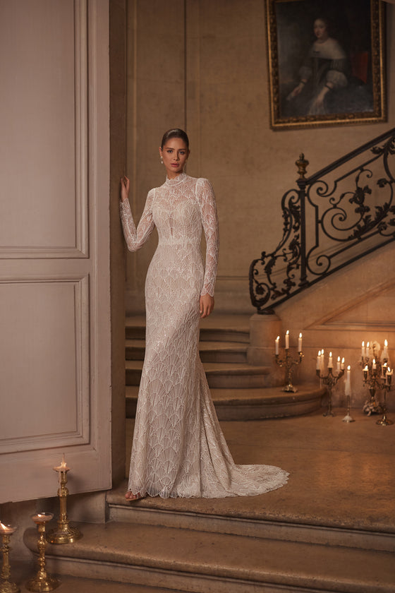 Robe de mariée sirène Juniona, avec une encolure montante, de longues manches ajustées et de la dentelle géométrique.