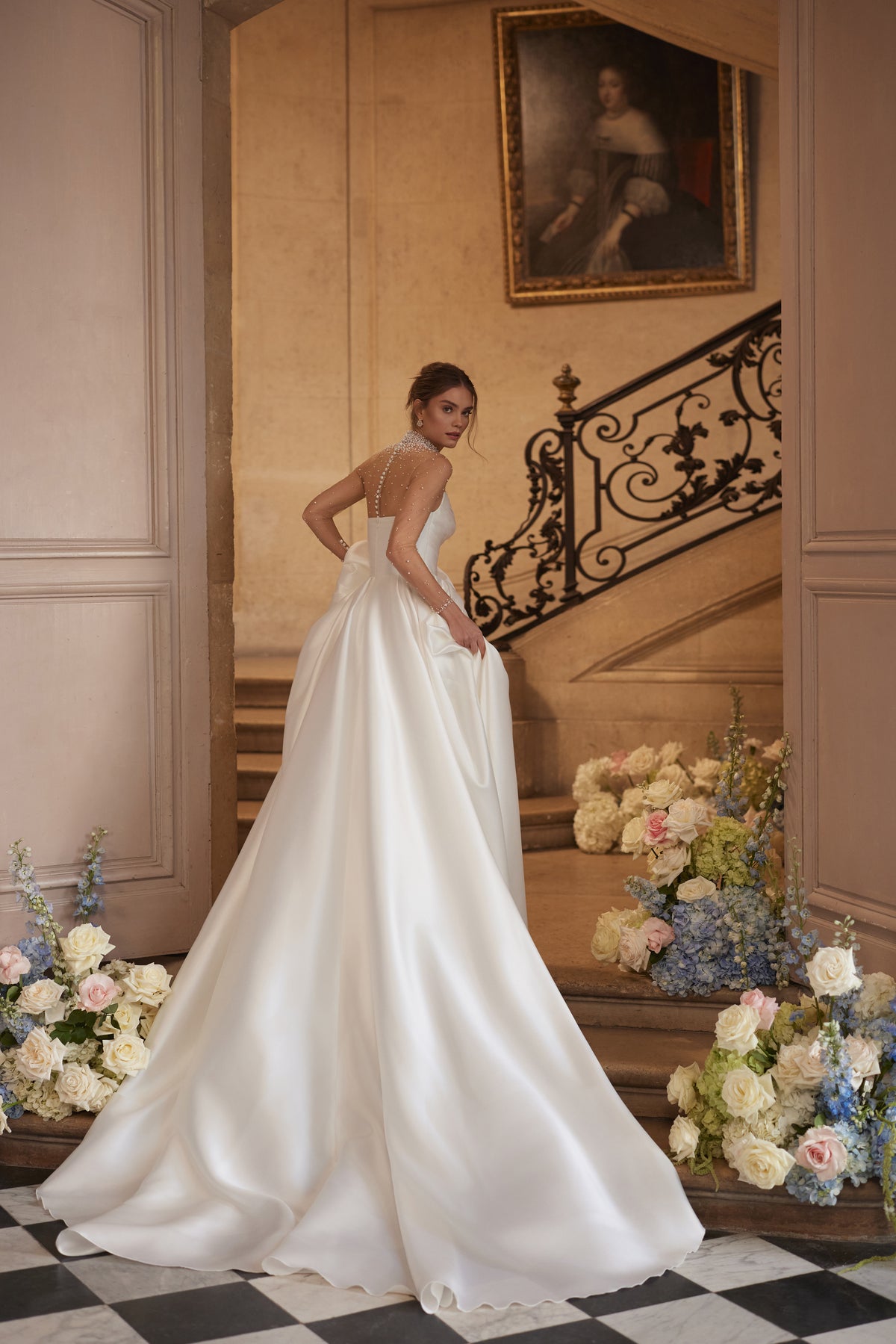 Robe de mariée Lucienne, avec un décolleté illusion orné de cristaux et une jupe drapée en satin avec une fente haute — collection Something Blue 2027.