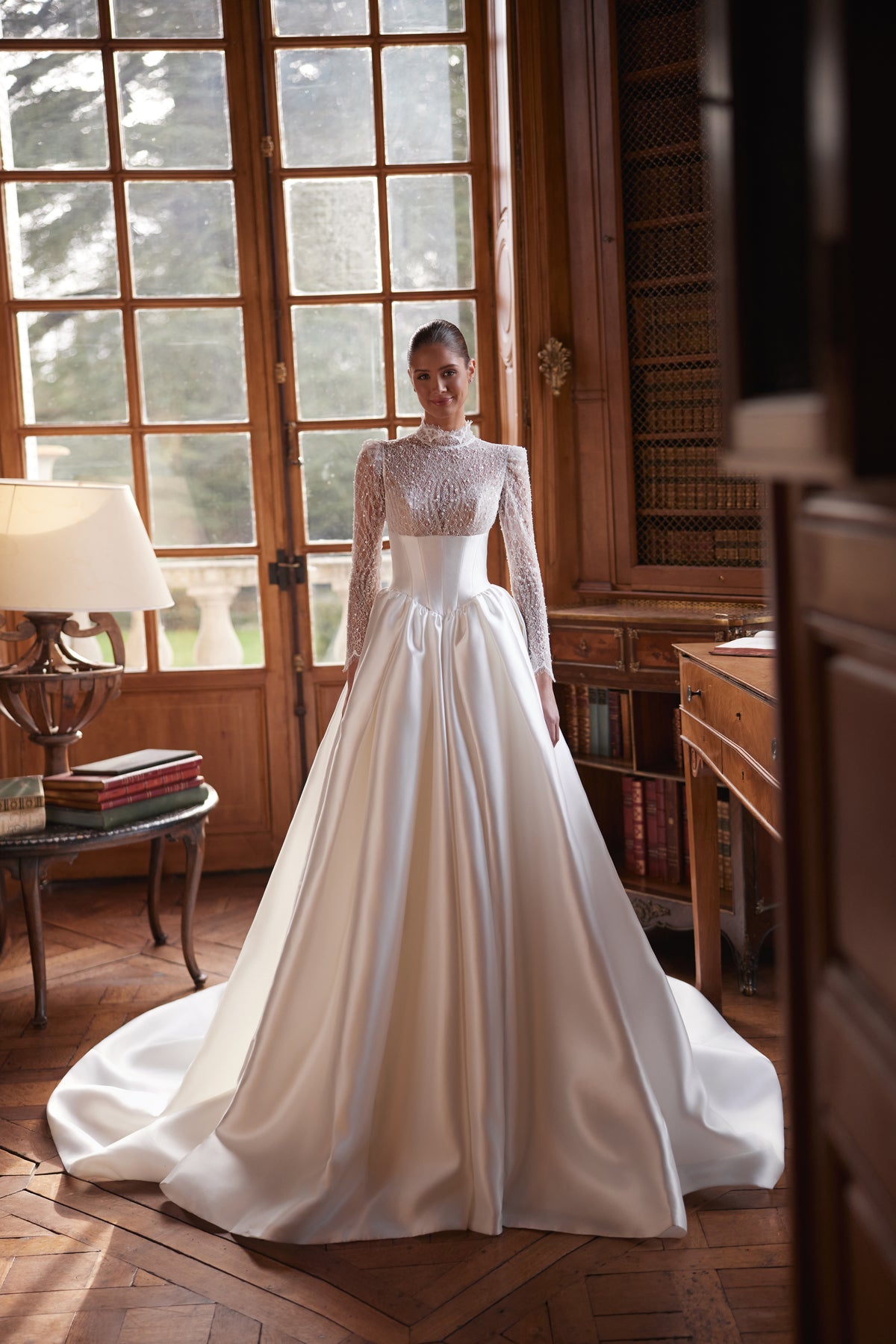 Robe de mariée Maristella, avec un corsage en dentelle à col montant, de longues manches et une jupe ample en satin.