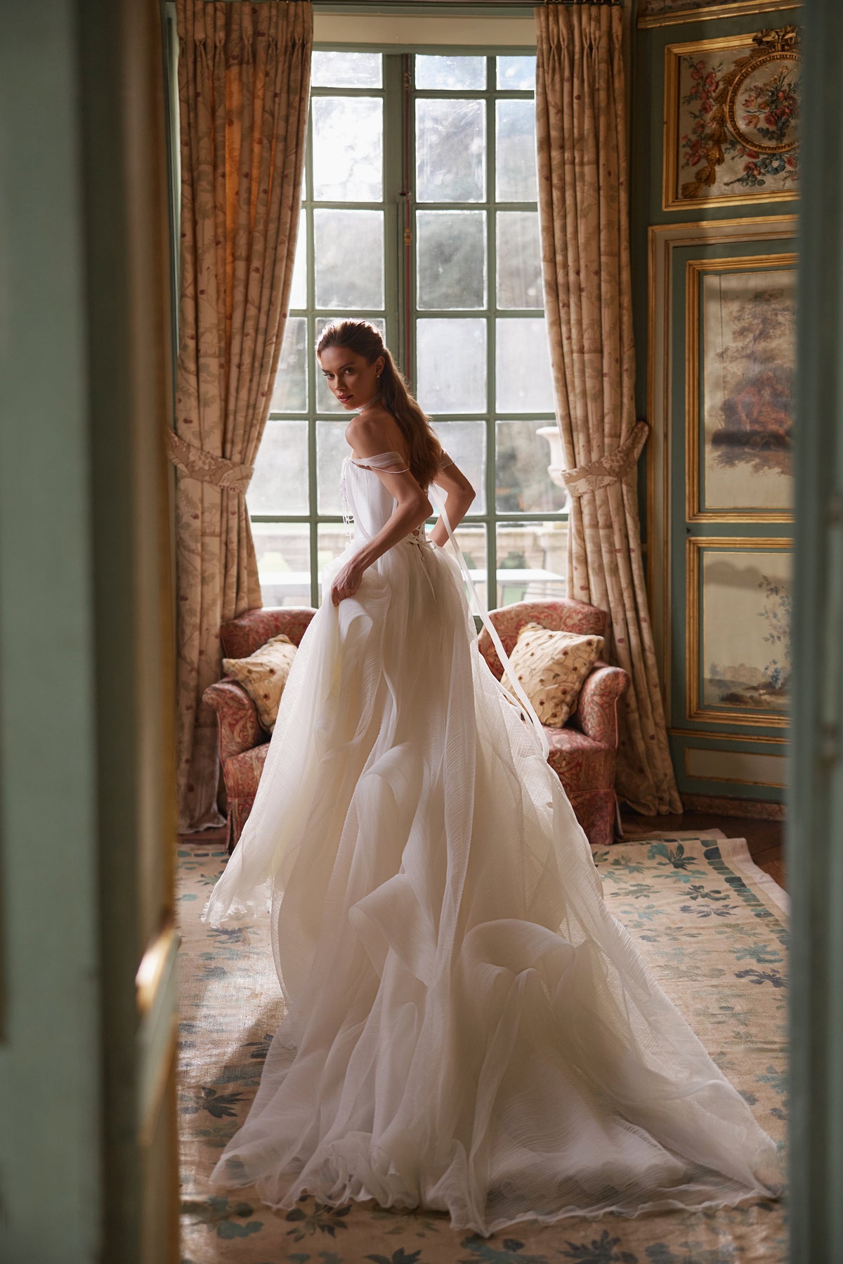 Robe de mariée Nerina, avec des détails évoquant des bijoux et des bretelles de tulle retombant sur les bras.