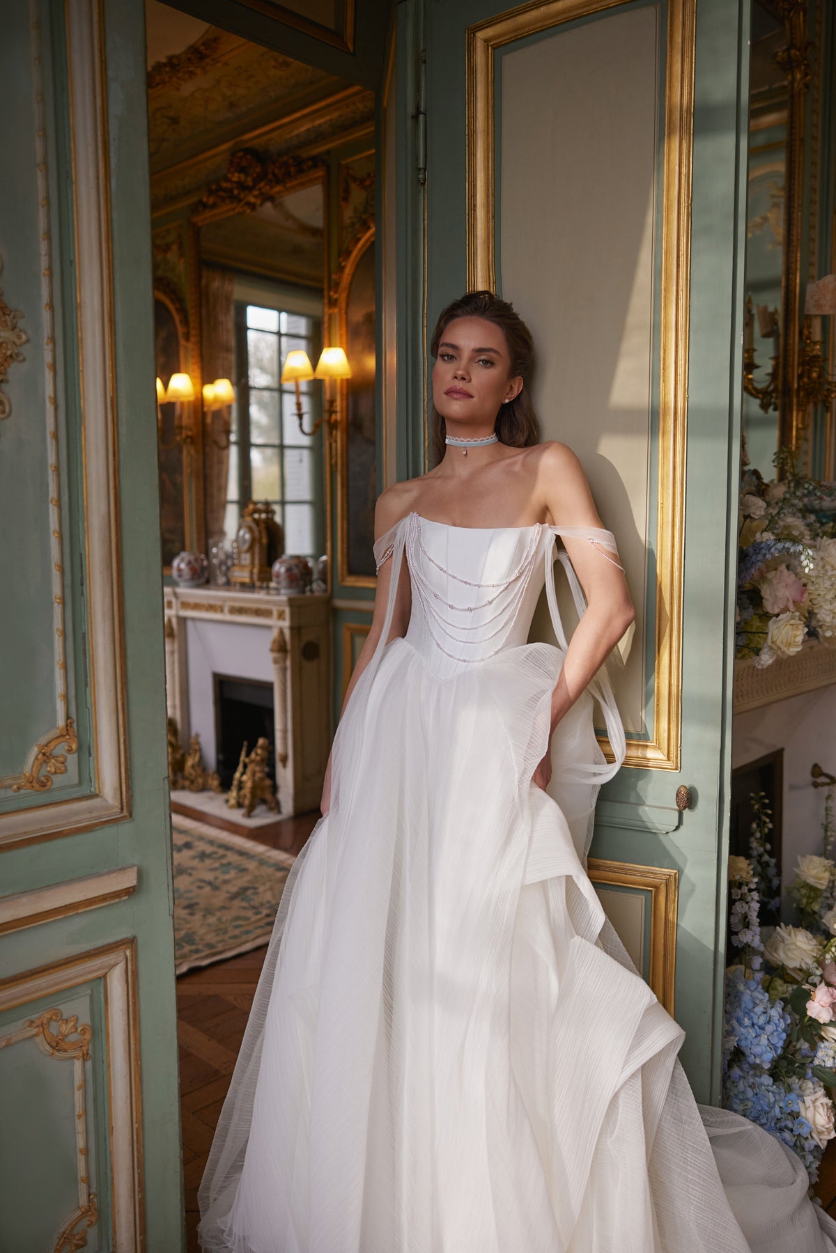 Robe de mariée Nerina, avec des détails évoquant des bijoux et des bretelles de tulle retombant sur les bras — collection Something Blue 2027, DAMA Couture.