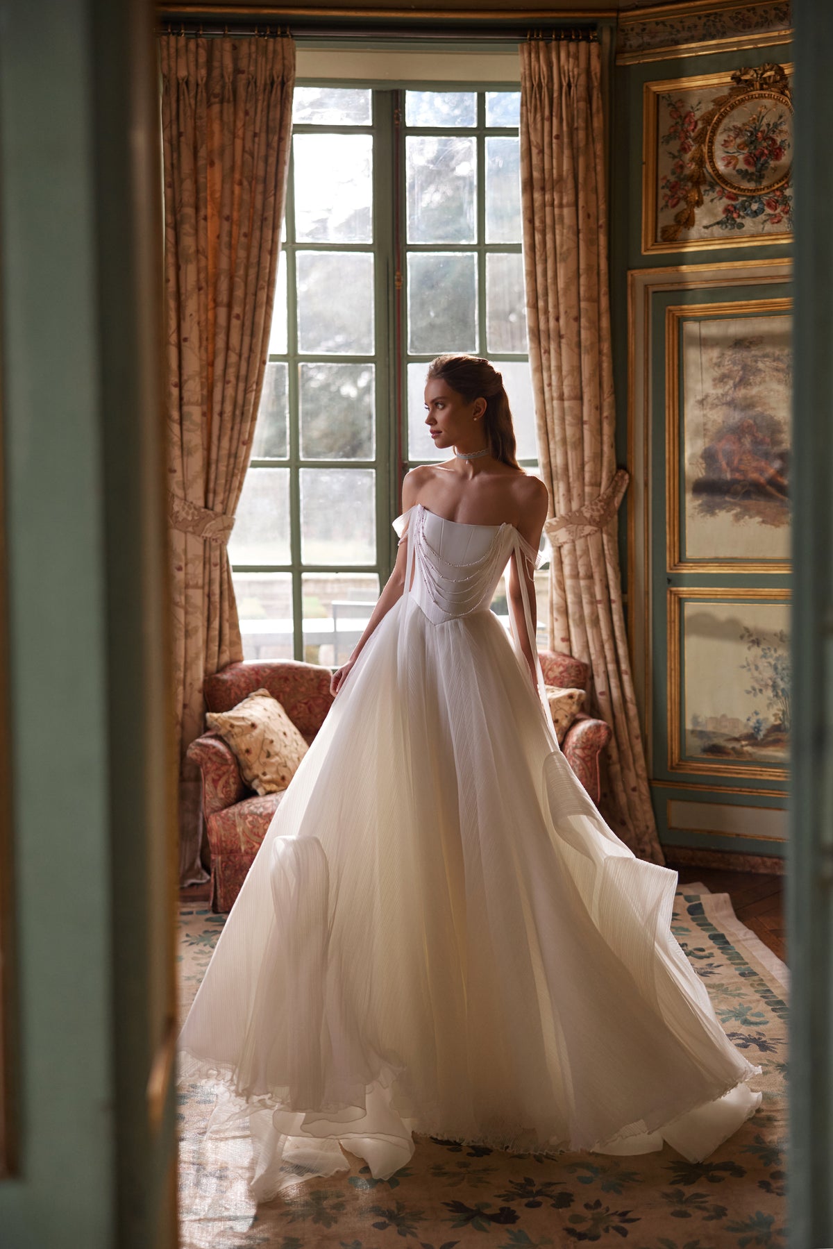 Robe de mariée Nerina, avec des détails évoquant des bijoux et des bretelles de tulle retombant sur les bras — collection Something Blue 2027.