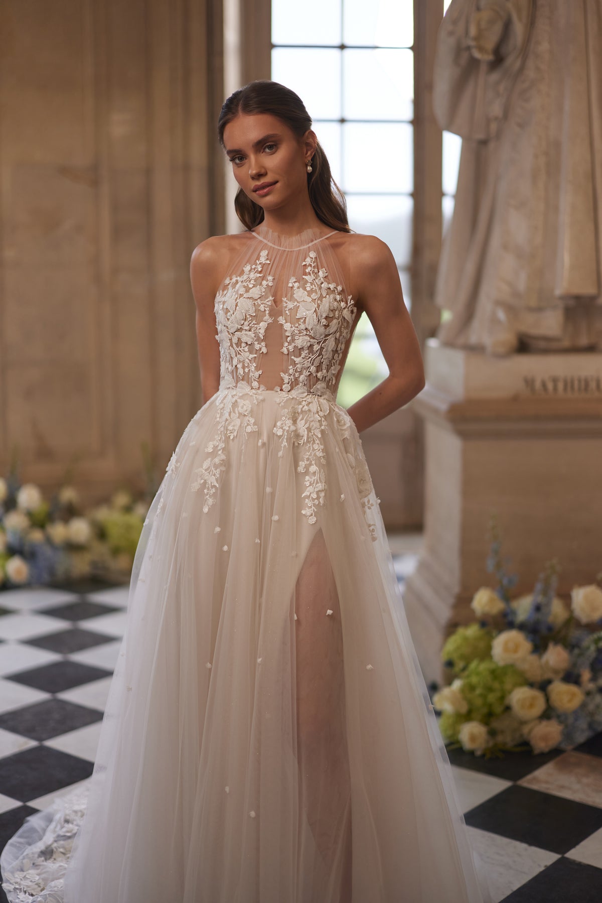 Robe de mariée Nilla, avec une encolure montante transparente et une jupe en tulle à dentelle florale.