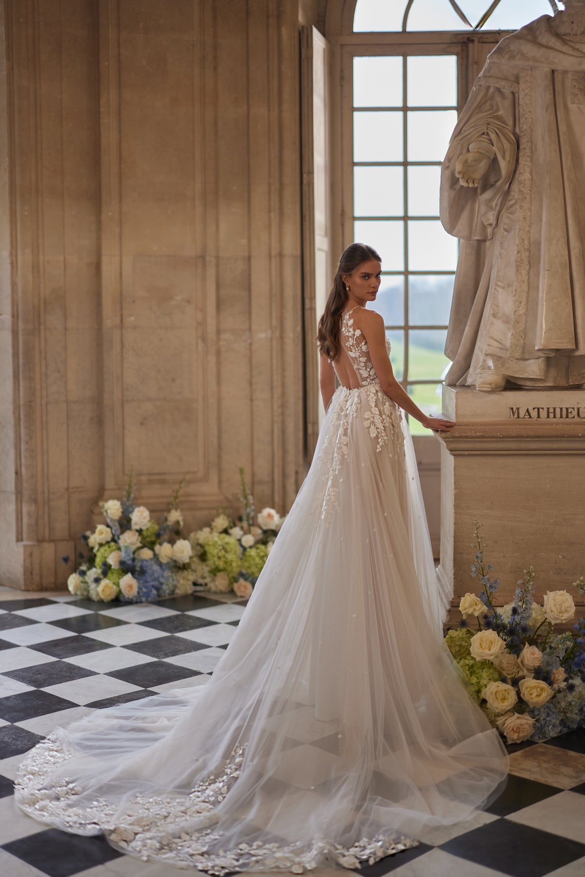 Robe de mariée Nilla, avec une encolure montante transparente et une jupe en tulle à dentelle florale — collection Something Blue 2027, DAMA Couture.