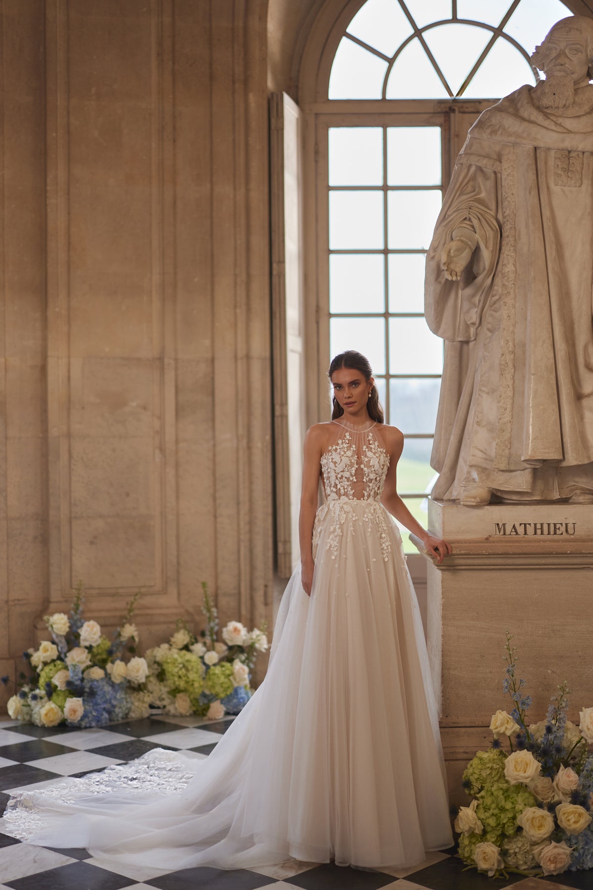 Robe de mariée Nilla, avec une encolure montante transparente et une jupe en tulle à dentelle florale — collection Something Blue 2027.
