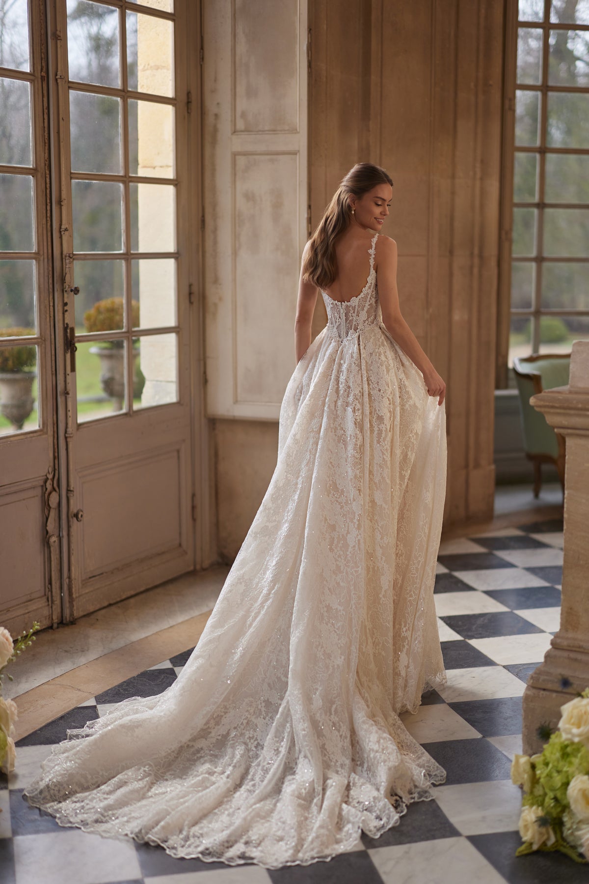 Robe de mariée Thetis, avec un corset transparent, des bretelles en dentelle et une somptueuse jupe en dentelle.