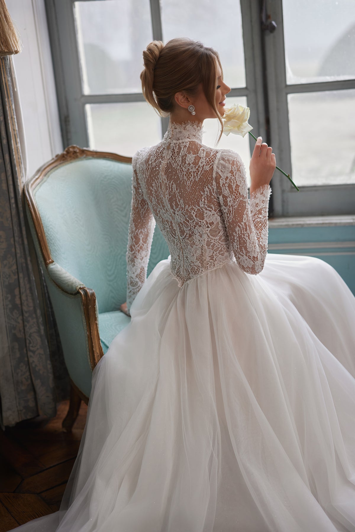 Robe de mariée Tonia, avec une encolure montante et de longues manches en dentelle transparente.