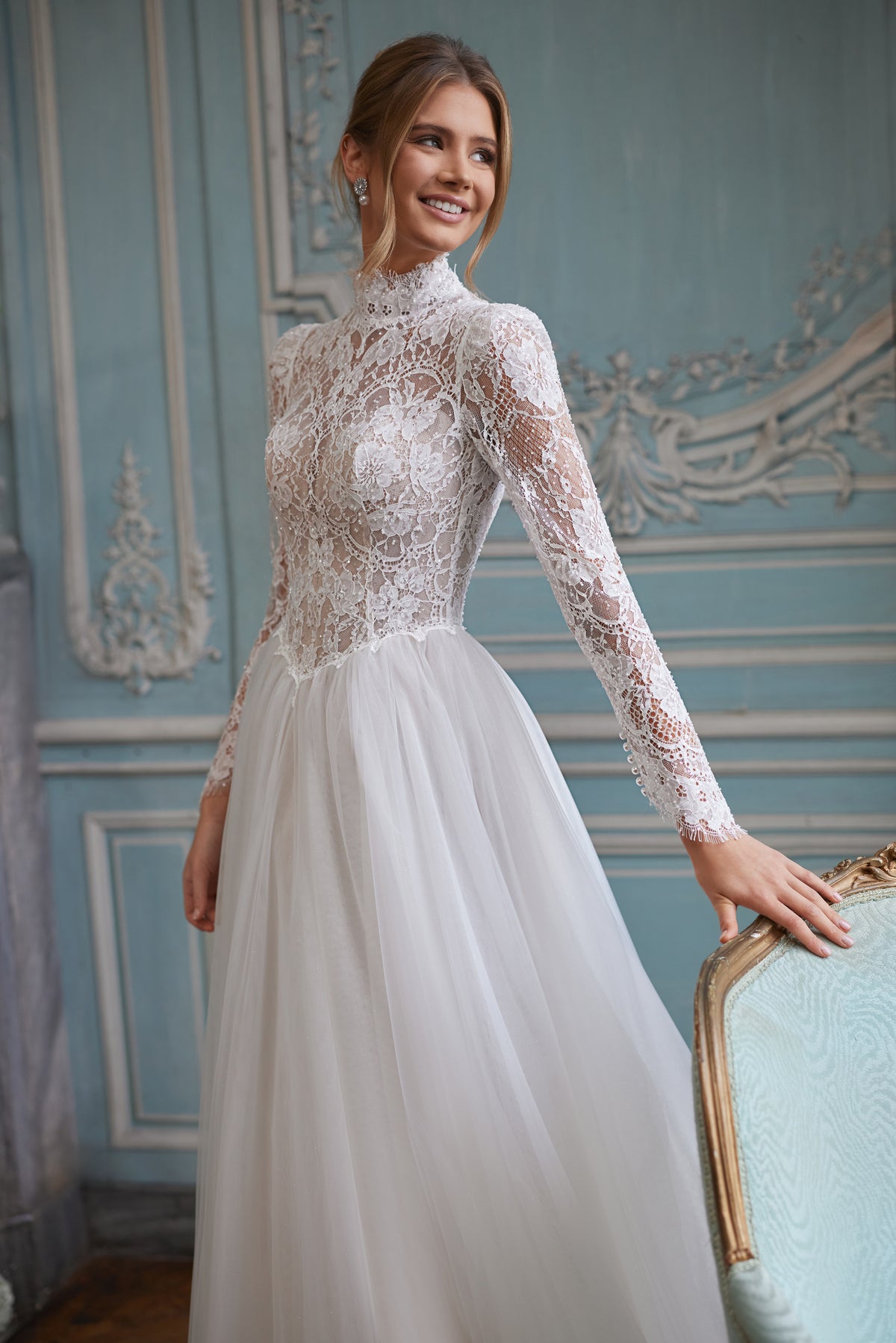 Robe de mariée Tonia, avec une encolure montante et de longues manches en dentelle transparente — collection Something Blue 2027, DAMA Couture.