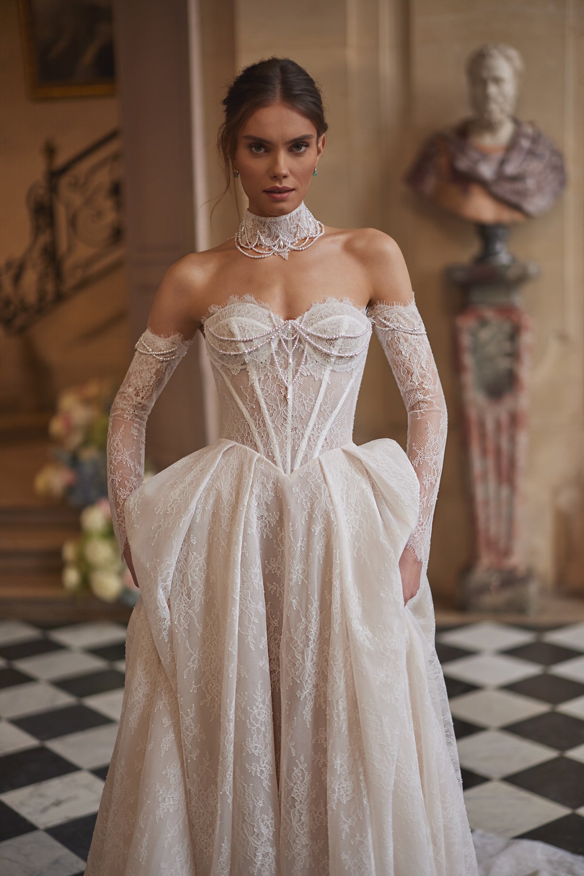 Robe de mariée Blanche, avec un corset perlé, une jupe souple en dentelle et des manches laissant les épaules dénudées — collection Something Blue 2027.