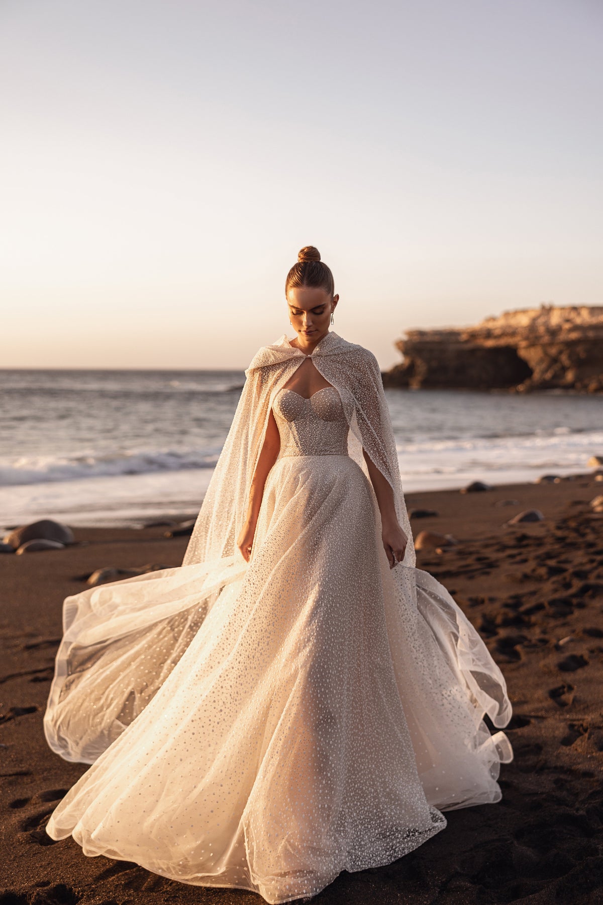 Cape de mariée Amira portée avec une robe à corset sans bretelles.