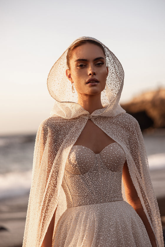 Cape de mariée Amira, avec une délicate capuche et du tulle orné.
