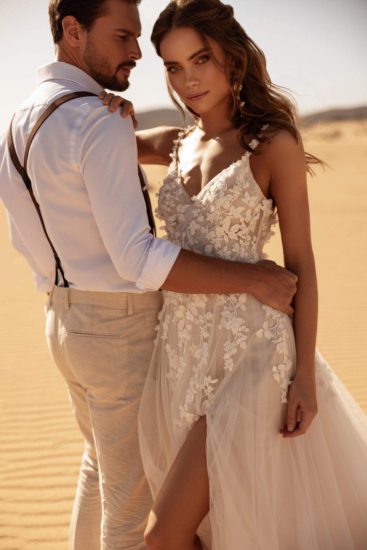 Robe de mariée Aviva, avec un corsage transparent en dentelle à fleurs en relief, dans la lumière du désert.