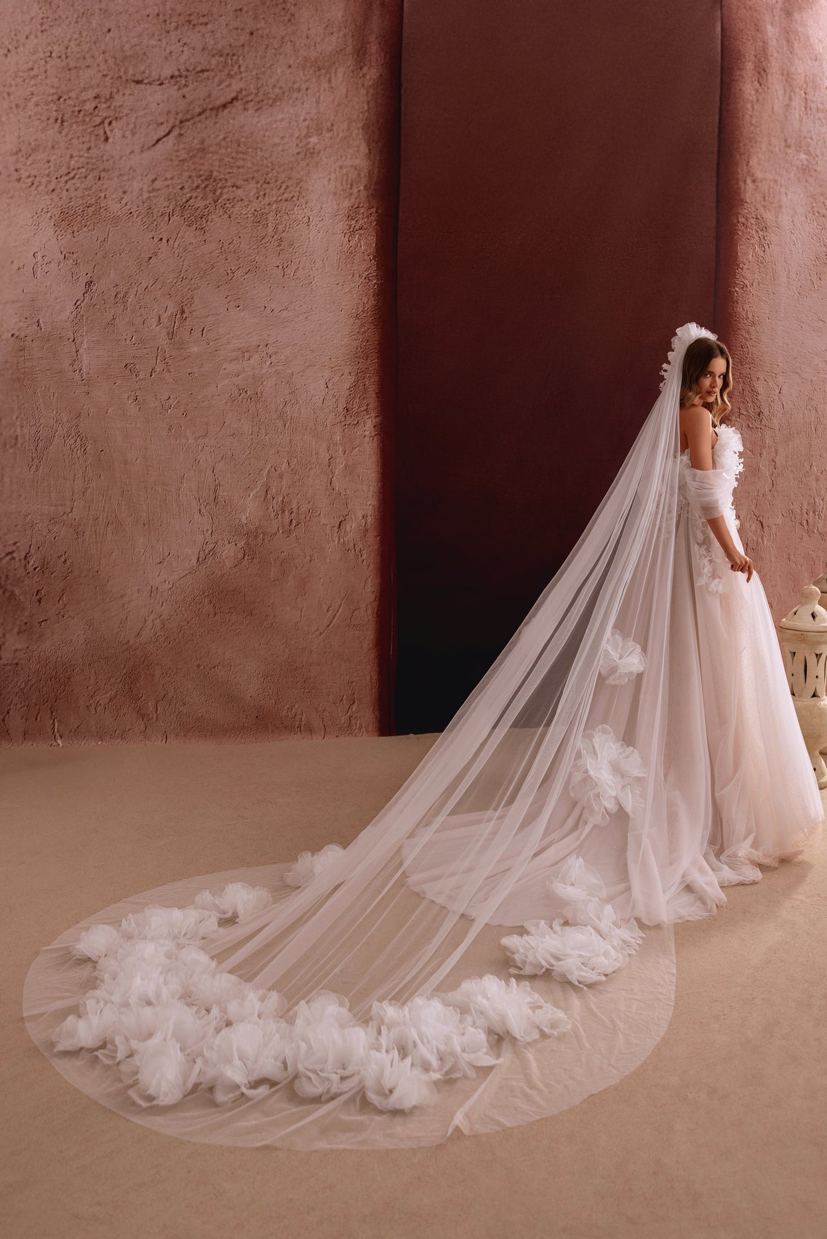 Long voile de mariée Bella, avec de délicates fleurs en relief à l’ourlet.