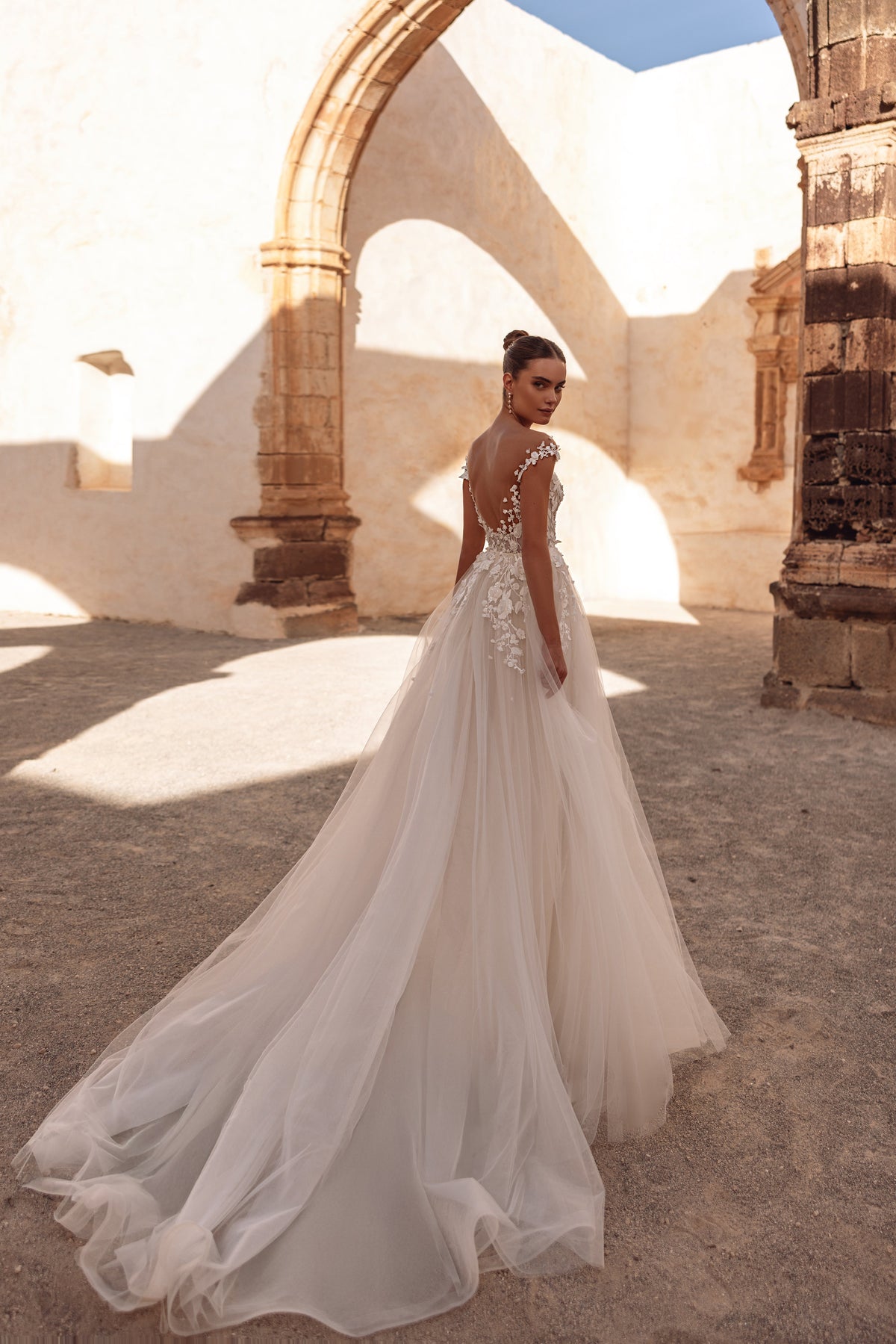 Gros plan sur la robe Andrea, son corsage en dentelle en relief et ses détails de tulle transparent.