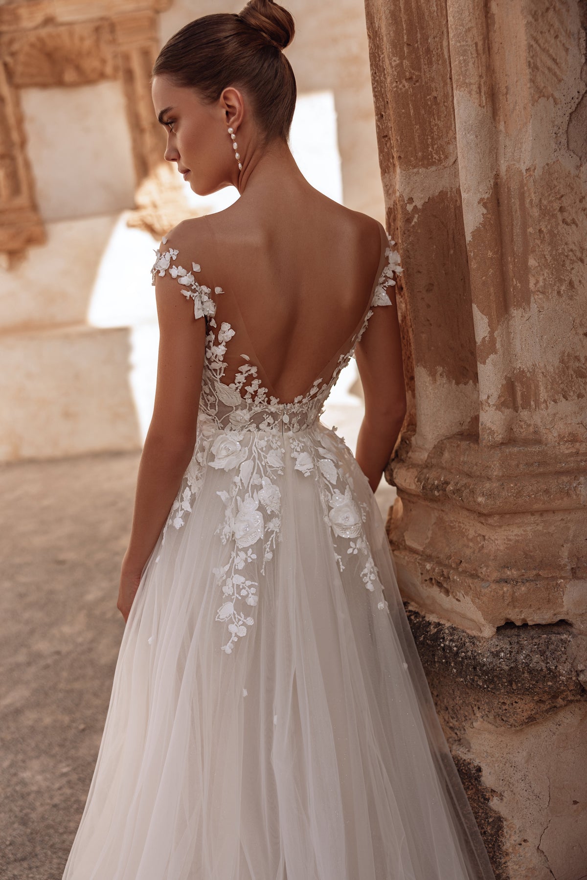 Robe de mariée Andrea, avec un dos nu et une longue traîne fluide.