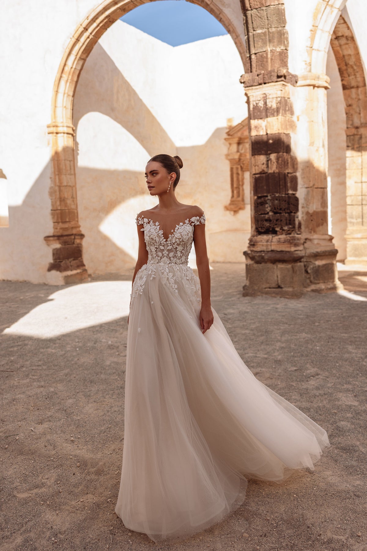 Robe de mariée Andrea, avec un corsage en dentelle aux épaules dénudées et une jupe légère en tulle.