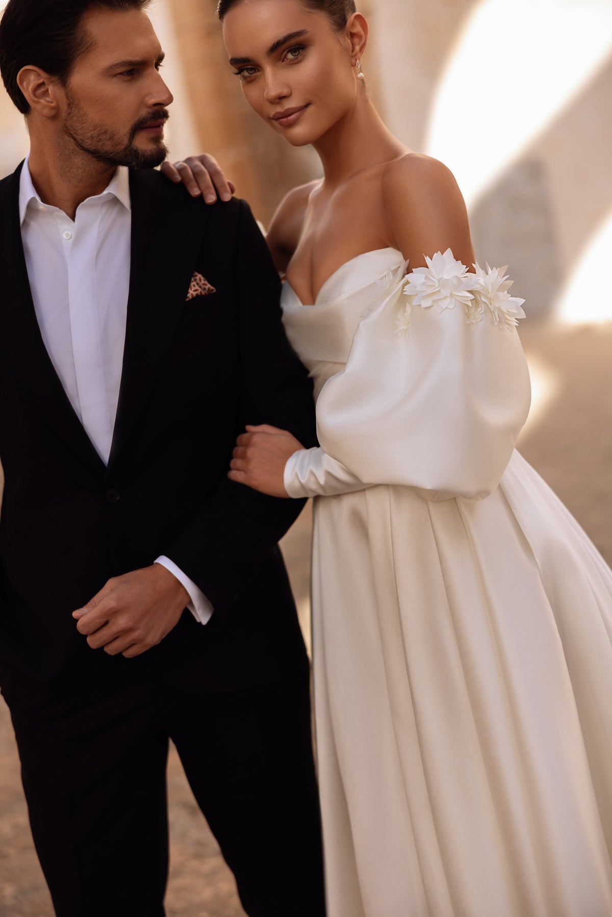 Robe de mariée Anika en satin, avec un décolleté cœur et une jupe volumineuse à la lumière naturelle.
