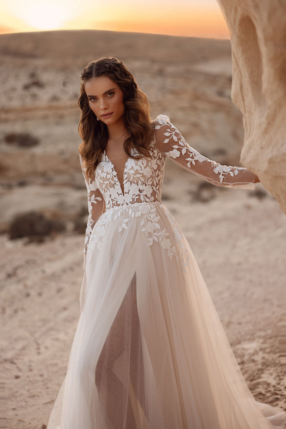 Robe de mariée Armori, avec une longue traîne en tulle et un corsage en dentelle, au coucher du soleil dans le désert.