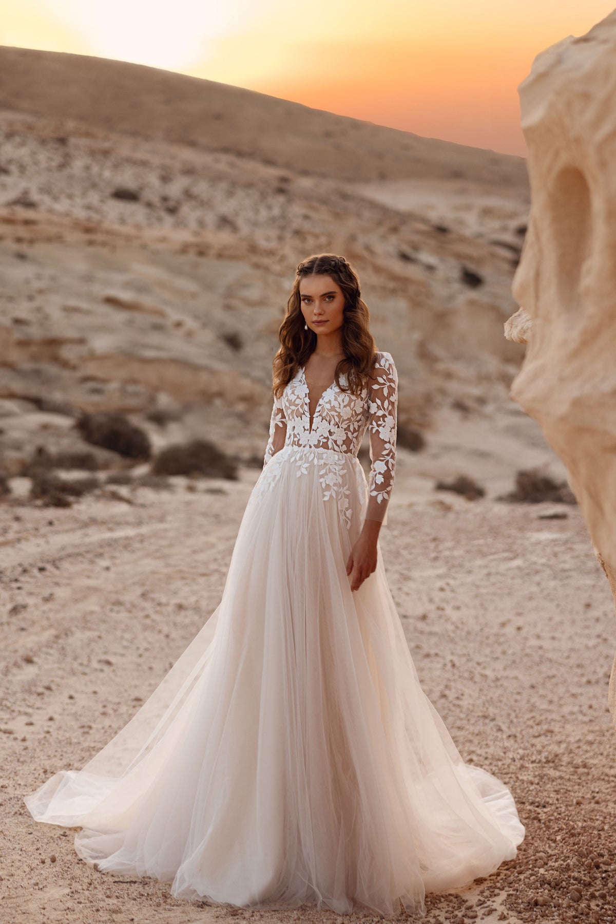 Robe de mariée Armori, avec un décolleté en V profond et des manches trois-quarts en dentelle.
