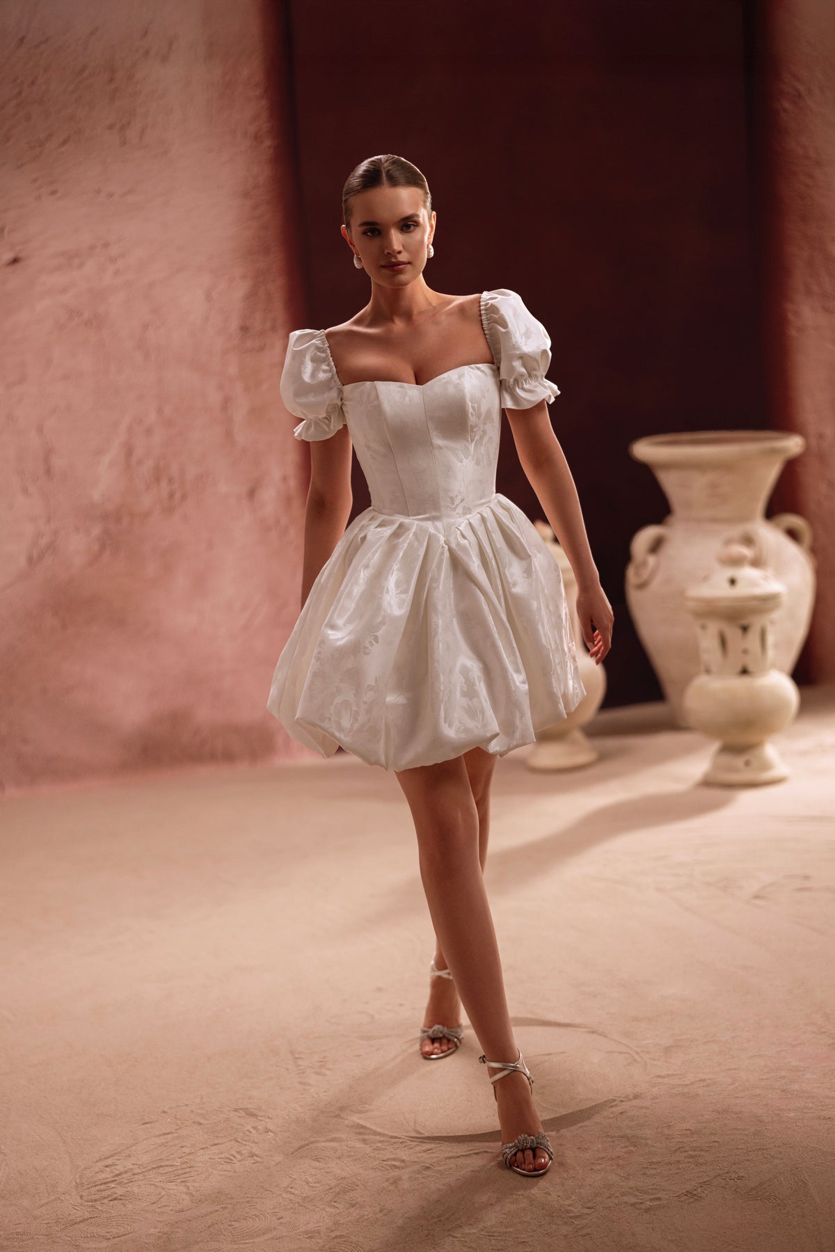 Robe de mariée courte Daphne, avec un corset lacé dans le dos et des manches bouffantes.