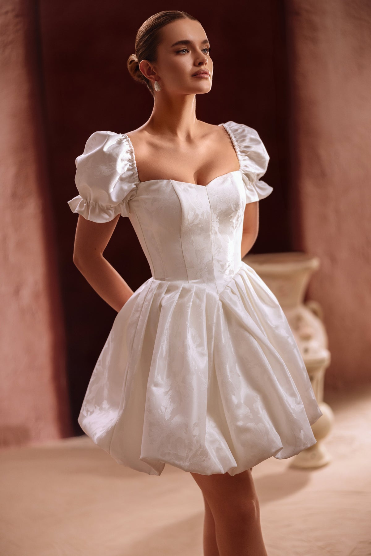 Robe de mariée courte Daphne, avec des manches bouffantes et un corset.